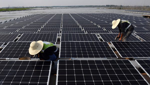 Рабочие на плавучей солнечной электростанции в Китае. Архивное фото